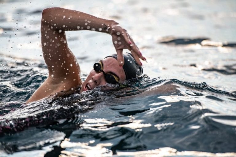 Open water swimmer building confidence and technique Open water swimmer practising front crawl technique during an intermediate coaching session in Stirlingshire